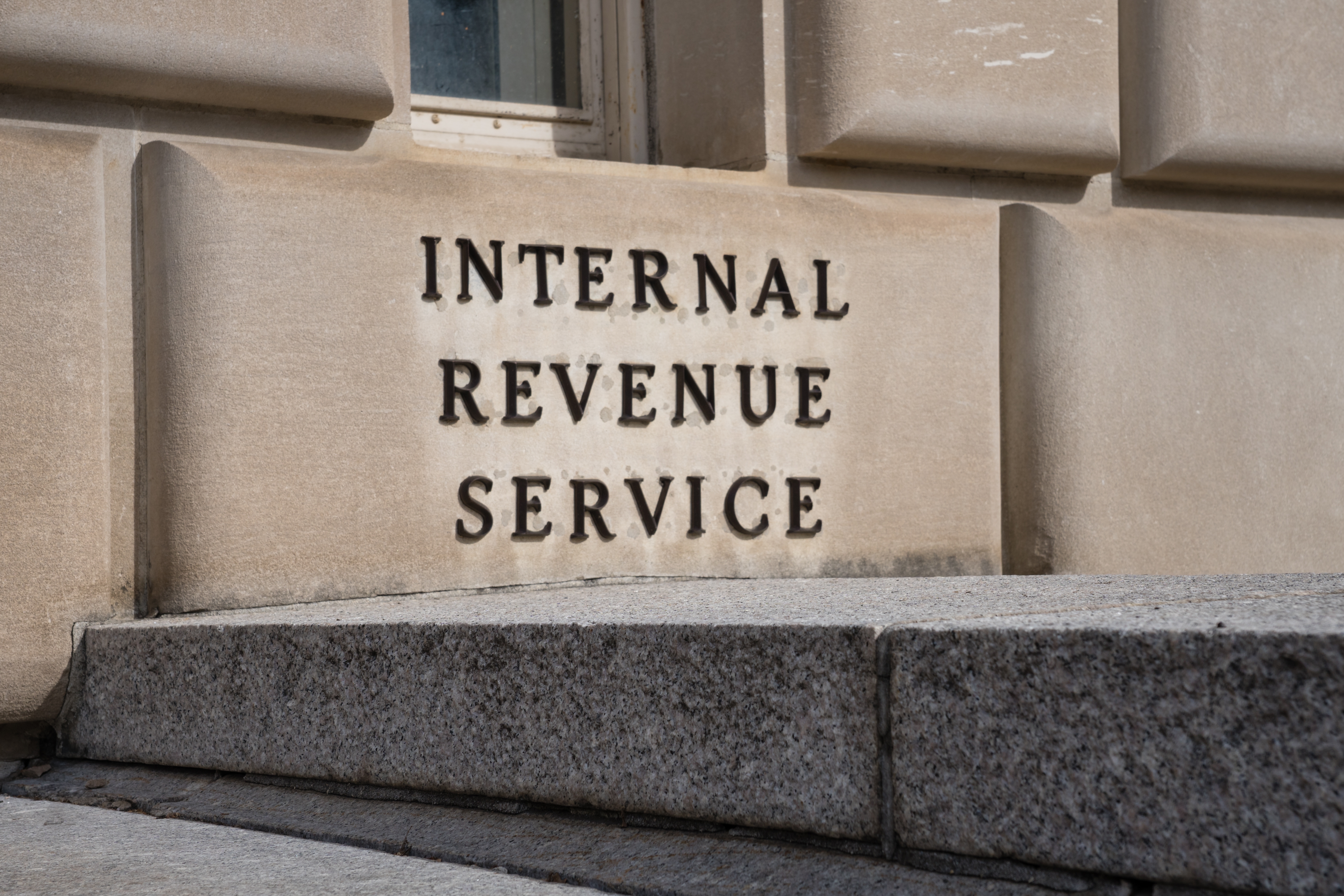 Internal Revenue Service building sign on a stone wall, emphasizing tax resolution and compliance.