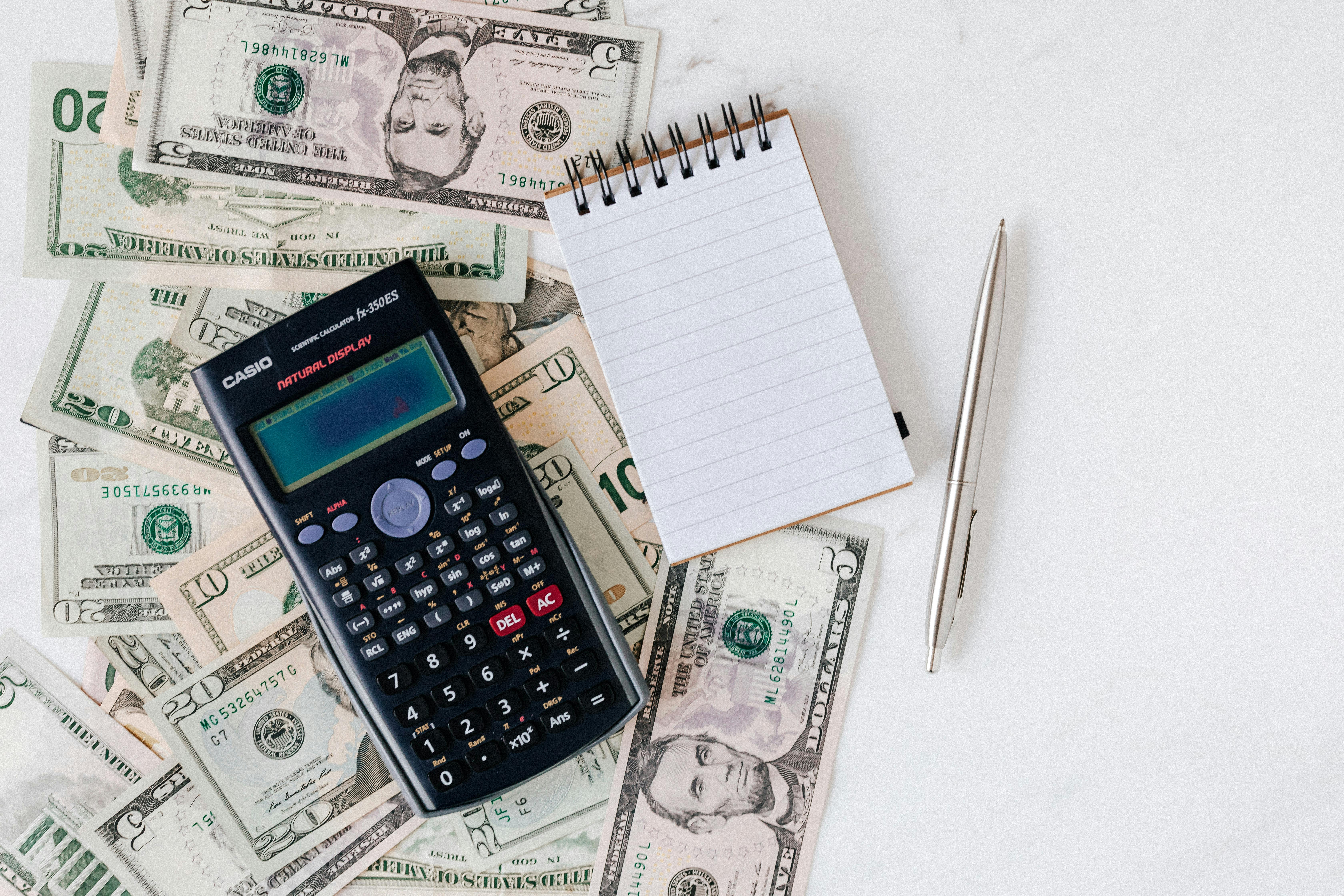 Calculator on cash and notepad for tax planning and financial management.